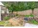 Secluded backyard featuring a fire pit area with gravel and a wood pile at 11765 Fairway Overlook, Fayetteville, GA 30215