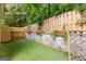 Backyard with a stone retaining wall, flower boxes, and artificial turf at 11765 Fairway Overlook, Fayetteville, GA 30215