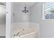 Bright bathroom featuring a soaking tub with tile surround and a window for natural light at 11765 Fairway Overlook, Fayetteville, GA 30215