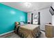 Comfortable bedroom featuring a teal accent wall, window view, and light wood dresser at 11765 Fairway Overlook, Fayetteville, GA 30215