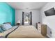 Comfortable bedroom with a teal accent wall, window view, and light wood dresser at 11765 Fairway Overlook, Fayetteville, GA 30215