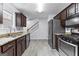 Kitchen with stainless steel appliances, granite countertops and dark wood cabinetry at 11765 Fairway Overlook, Fayetteville, GA 30215