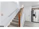 Carpeted stairway with wooden banister, white risers and accent wall at 11765 Fairway Overlook, Fayetteville, GA 30215