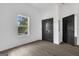 Bright bedroom with a window view and featuring wood-look flooring and a closet with black doors at 1226 Byewood Sw Ln, Atlanta, GA 30310