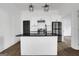 Stylish kitchen with white cabinets, black countertops, a stainless steel refrigerator, and modern lighting at 1226 Byewood Sw Ln, Atlanta, GA 30310