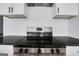 Stainless steel stove top with black knobs, tiled backsplash, and white cabinets at 1226 Byewood Sw Ln, Atlanta, GA 30310
