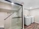 Modern bathroom featuring a glass enclosed shower with tan tile and updated fixtures, plus a washer and dryer at 507 N Green Cir, Mcdonough, GA 30252