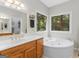 Well-lit bathroom featuring a soaking tub, vanity, and large window at 507 N Green Cir, Mcdonough, GA 30252