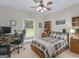 Cozy bedroom with a plaid comforter, ceiling fan, and a window overlooking the yard at 507 N Green Cir, Mcdonough, GA 30252