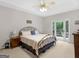 Comfortable bedroom features a metal bed frame and access to a private balcony at 507 N Green Cir, Mcdonough, GA 30252