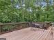 Wooden deck featuring an outdoor table and seating with wooded views at 507 N Green Cir, Mcdonough, GA 30252