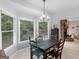 Bright dining area features a rustic wooden table, chandelier, and natural light from large windows at 507 N Green Cir, Mcdonough, GA 30252