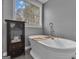 Bright bathroom featuring a freestanding tub, a large window, and modern fixtures at 140 Laurel Lake Rd, Tyrone, GA 30290