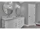 Stylish bathroom with double vanity, marble countertop, round mirrors, and ample storage space at 140 Laurel Lake Rd, Tyrone, GA 30290