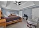 This bedroom features a tray ceiling, ceiling fan, and neutral walls with a comfy chair at 140 Laurel Lake Rd, Tyrone, GA 30290