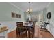 Sunlit dining room featuring a wooden table, bench seating, piano, and modern chandelier, perfect for Gathering gatherings at 140 Laurel Lake Rd, Tyrone, GA 30290