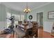 Inviting dining area with wood table, bench seating, chandelier, and abundant natural light from the large windows at 140 Laurel Lake Rd, Tyrone, GA 30290