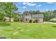 Inviting two-story home with mature trees and a well manicured front yard at 140 Laurel Lake Rd, Tyrone, GA 30290