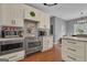Well-lit kitchen with stainless steel appliances, white cabinets and wood floors at 140 Laurel Lake Rd, Tyrone, GA 30290