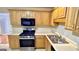 Spacious kitchen featuring light wood cabinets, stainless steel appliances, and modern fixtures at 6638 Creek Turn Dr, Rex, GA 30273