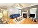 Cozy living room with a fireplace, ceiling fan, hardwood floors, and ample natural light at 6638 Creek Turn Dr, Rex, GA 30273