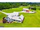 Expansive estate featuring a beautiful blue house, detached garage, and a red barn on a large green lawn at 385 Liberty Church Rd, Carrollton, GA 30116