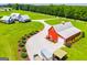 Modern farmhouse and a red barn, surrounded by manicured lawns and a gravel driveway at 385 Liberty Church Rd, Carrollton, GA 30116