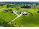 Expansive aerial view showcasing the modern farmhouse, barn, and surrounding lush green landscape at 385 Liberty Church Rd, Carrollton, GA 30116