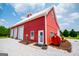 Red barn featuring two garage doors, a white roof, and a concrete walkway at 385 Liberty Church Rd, Carrollton, GA 30116