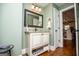 Powder room featuring a vanity with granite countertop and decorative mirror at 385 Liberty Church Rd, Carrollton, GA 30116