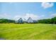 A nice, blue home is shown with a large, well-kept lawn and cloudy, blue skies in the background at 385 Liberty Church Rd, Carrollton, GA 30116