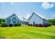 Charming home with a backyard and beautiful landscaping and a light blue exterior on a sunny day at 385 Liberty Church Rd, Carrollton, GA 30116