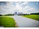 Exterior of house with a gravel driveway and expansive green lawn under a cloudy blue sky at 385 Liberty Church Rd, Carrollton, GA 30116