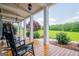 Spacious front porch with rocking chairs, offering a relaxing outdoor space overlooking greenery at 385 Liberty Church Rd, Carrollton, GA 30116