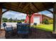 Beautiful gazebo with a table and chairs with string lights and nice home and barn in the background at 385 Liberty Church Rd, Carrollton, GA 30116