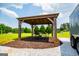 Beautiful gazebo with a table and chairs with string lights surrounded by gravel and green grass at 385 Liberty Church Rd, Carrollton, GA 30116