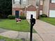 Traditional two-story home with brick and siding, featuring a one-car garage and well-maintained lawn at 5057 Windsor Forrest Lane, Atlanta, GA 30349