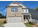 New construction two-story home featuring a two-car garage, gray brick, and gray vinyl siding at 35 Fraser Ln # 123B, Auburn, GA 30011