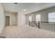 Carpeted upstairs loft area featuring a railing, neutral walls and three windows at 35 Fraser Ln # 123B, Auburn, GA 30011