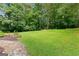 Spacious backyard featuring lawn, mature trees and planting bed at 205 N Strathmore Dr, Sharpsburg, GA 30277