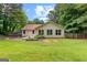 Expansive backyard featuring a lush lawn, wooden planters, and a charming single-story home exterior at 205 N Strathmore Dr, Sharpsburg, GA 30277