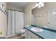 Bathroom features a vanity with blue countertop, white cabinet and shower with curtain at 205 N Strathmore Dr, Sharpsburg, GA 30277