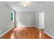 A bright bedroom with hardwood floors, a ceiling fan and natural light from a large window at 205 N Strathmore Dr, Sharpsburg, GA 30277