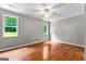 Bedroom features gleaming hardwood floors, neutral walls, and natural light from dual windows at 205 N Strathmore Dr, Sharpsburg, GA 30277