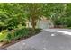 Exterior of home with attached garage, landscaped yard and lush green trees at 205 N Strathmore Dr, Sharpsburg, GA 30277