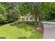 Landscaped front yard with a lush lawn and a driveway for parking at 205 N Strathmore Dr, Sharpsburg, GA 30277
