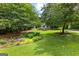 Charming home with a beautiful landscaped front yard and mature trees at 205 N Strathmore Dr, Sharpsburg, GA 30277