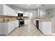 Bright kitchen featuring white cabinets, stainless steel appliances, and tile flooring at 205 N Strathmore Dr, Sharpsburg, GA 30277