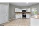 Bright kitchen featuring white cabinetry, stainless steel appliances, and access to dining areas at 205 N Strathmore Dr, Sharpsburg, GA 30277