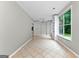 Open living room with built-in shelves, tile flooring, and bright natural light from large windows at 205 N Strathmore Dr, Sharpsburg, GA 30277